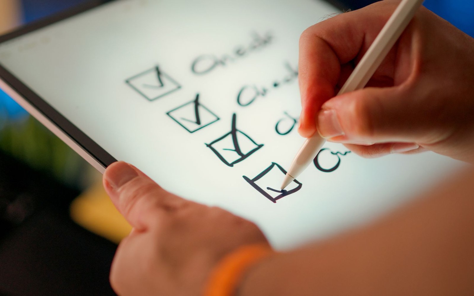 Hand using a stylus to check off boxes on a digital checklist on a tablet