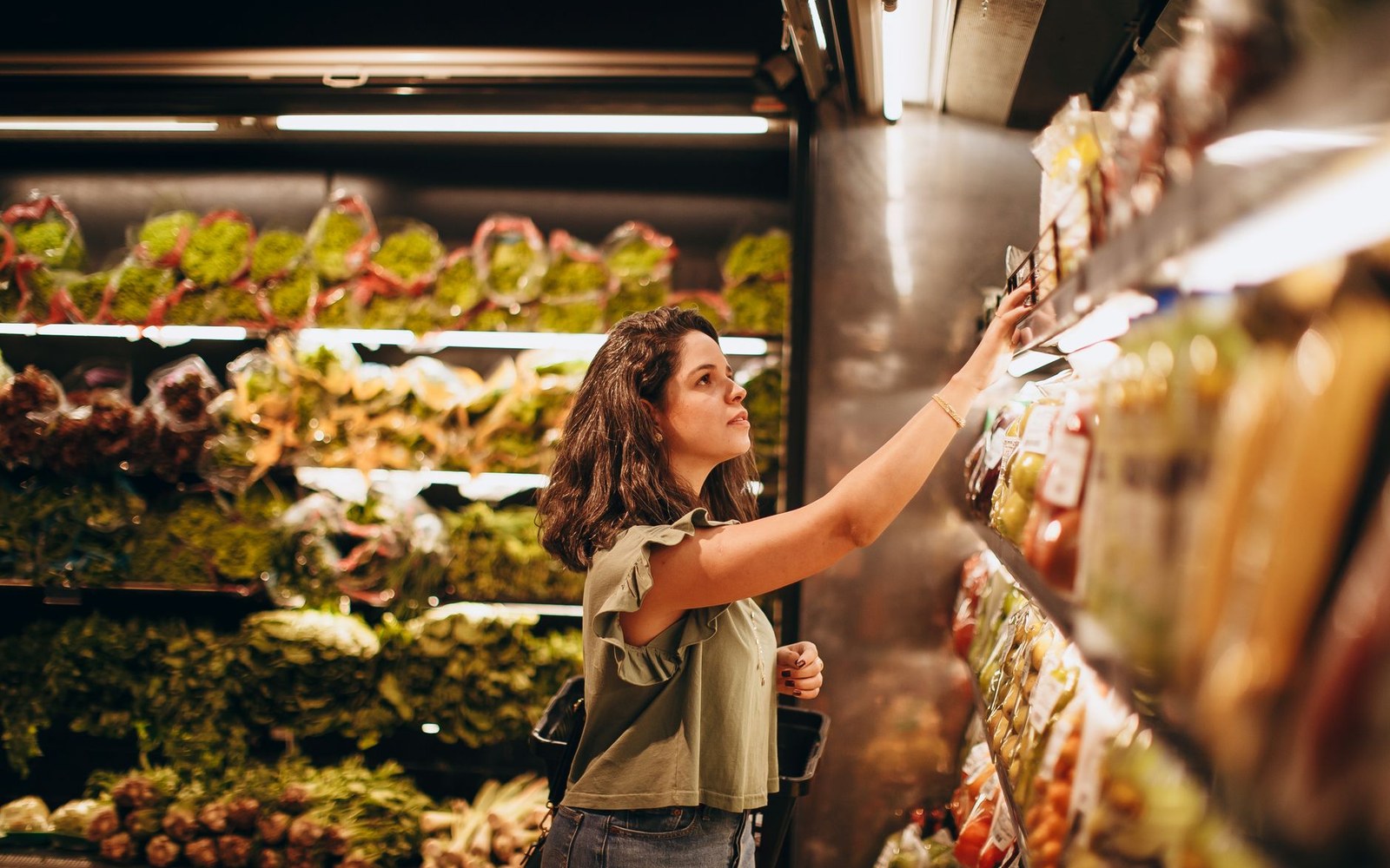 A shopper standing back reading a full shelf of near-identical packets